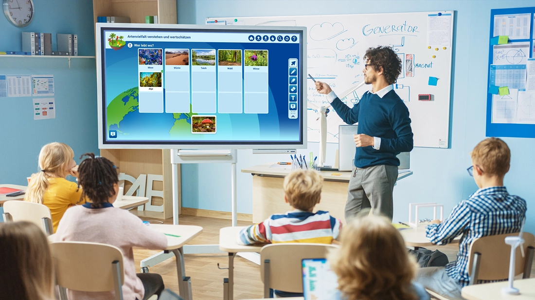 Ein Lehrer zeigt auf eine digitale Tafel. Er verwendet die digitalen Bildungsangebote der BASF